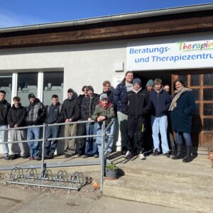 Gruppe von Jugendlichen und Mitarbeitenden vor dem Beratungs- und Therapiezentrum „Therapino" der GfG