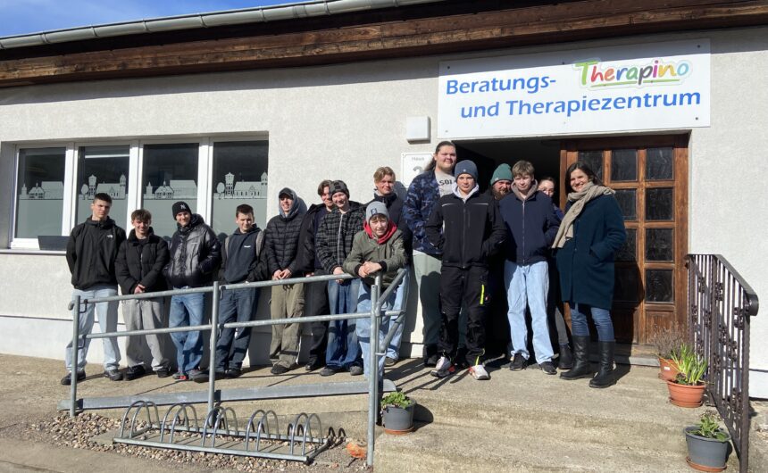 IMG_0082 (3) Gruppe von Jugendlichen und Mitarbeitenden vor dem Beratungs- und Therapiezentrum „Therapino" der GfG