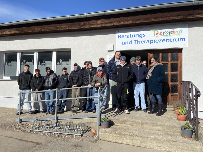 Gruppe von Jugendlichen und Mitarbeitenden vor dem Beratungs- und Therapiezentrum „Therapino" der GfG
