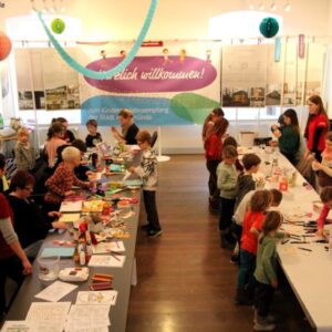 Kinder und Helfende basteln beim Kinderneujahrsempfang der Stadt Angermünde unter dem Banner „Herzlich willkommen"