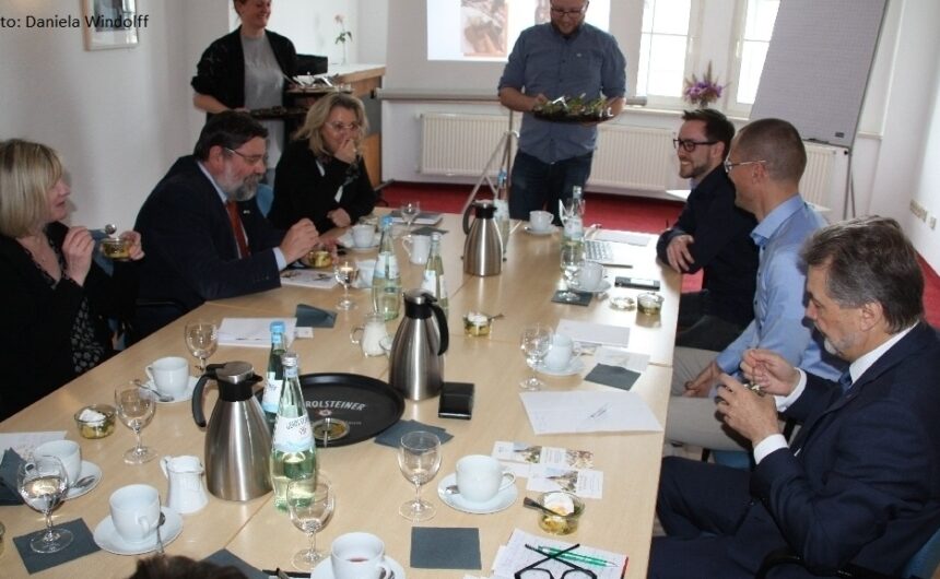 Besuch Unternehmervereinigung Uckermark im Hotel 1912 Angermünde Mehrere Personen sitzen bei einer Besprechung an einem gedeckten Konferenztisch – Austausch und Vernetzung der GfG