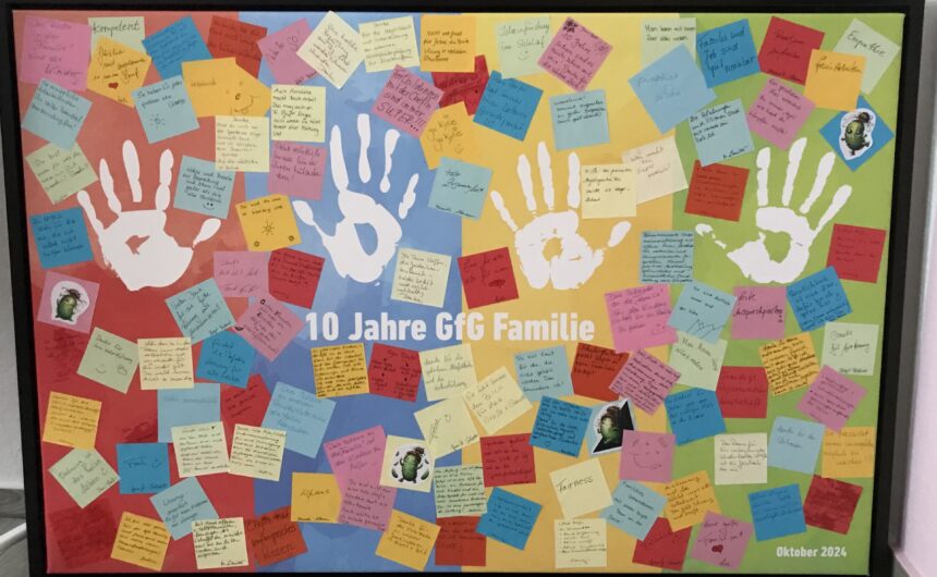 IMG_1484 Bunte Pinnwand mit Handabdrücken und vielen beschriebenen Zetteln zum Jubiläum „10 Jahre GfG Familie", Oktober 2024
